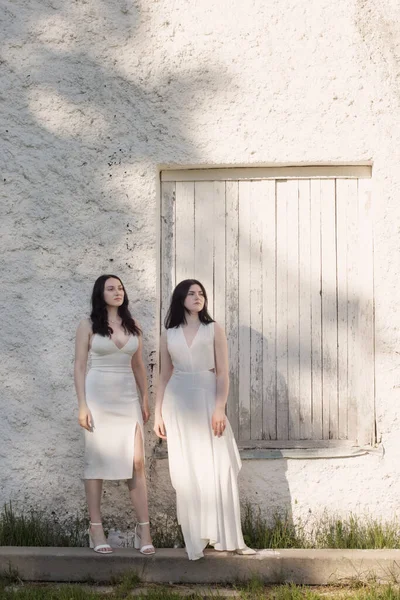 Dwie Młode Dziewczyny Białej Sukience Tle Stary Biały Mur — Zdjęcie stockowe