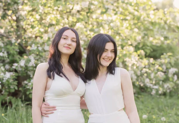 Δύο Νεαρά Κορίτσια Λευκό Φόρεμα Φόντο Ανθισμένη Μηλιά — Φωτογραφία Αρχείου