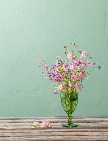 Дикие Цветы Зеленом Бокале Фоне Зеленой Стены — стоковое фото