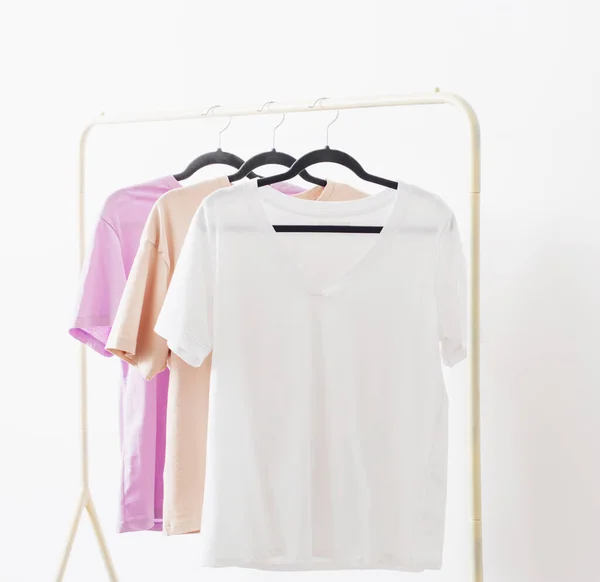 women\'s t-shirts on  hanger on  white background
