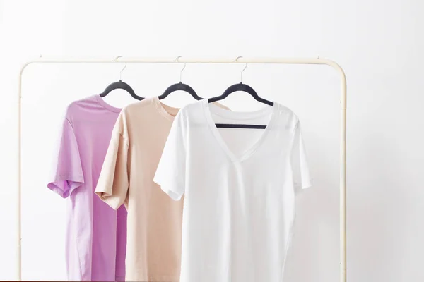 women\'s t-shirts on  hanger on  white background