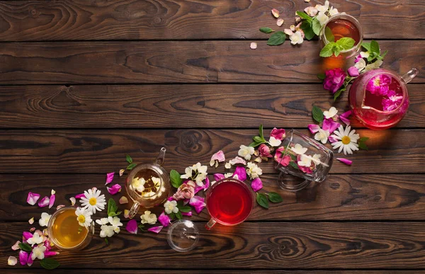 Különböző Teák Gyógynövényekkel Virágokkal Egy Sötét Asztalon Felülnézetből — Stock Fotó