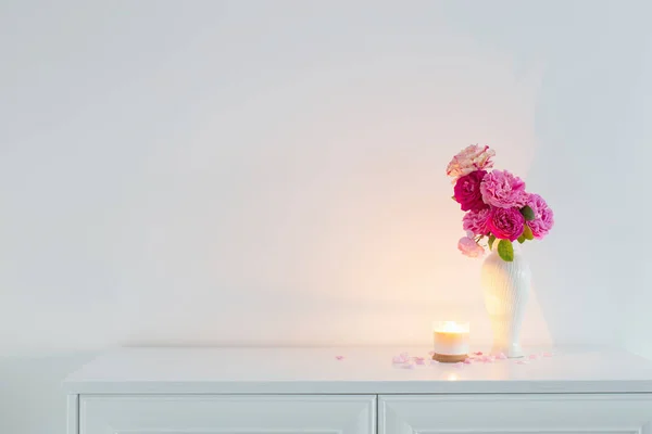 花瓶里的粉红玫瑰 背景白墙上燃着蜡烛 — 图库照片