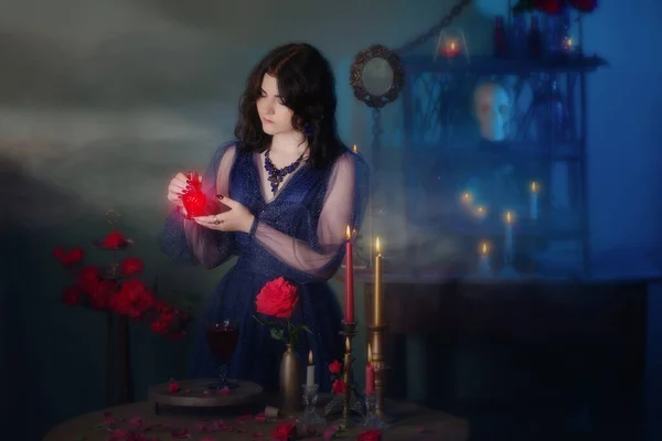 在黑暗的房间里 身穿蓝色复古服装 头戴红玫瑰花香药水的年轻漂亮女人 — 图库照片