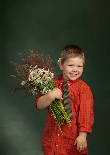 緑の背景に野生の花を持つ小さな男の子のヴィンテージ肖像画 — ストック写真