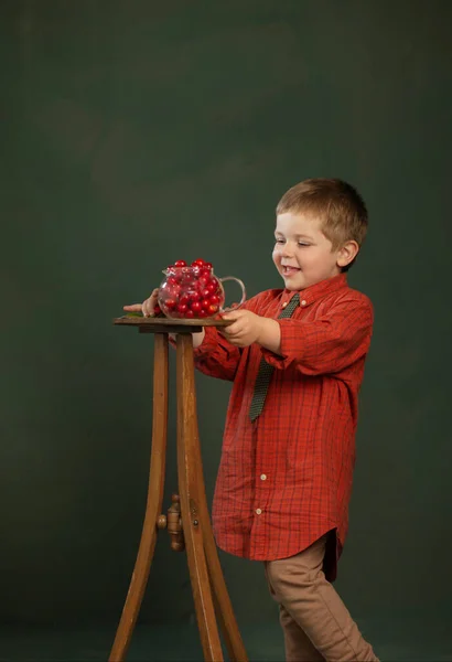 Μικρό Αστείο Αγόρι Κεράσια Στο Παρασκήνιο Σκούρο Πράσινο Τοίχο — Φωτογραφία Αρχείου