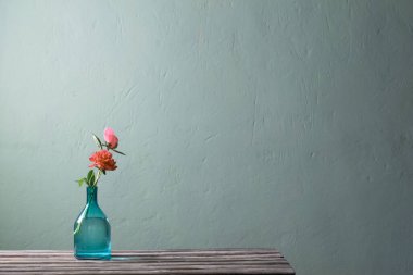 Yeşil arka planda cam vazoda pembe şakayıklar