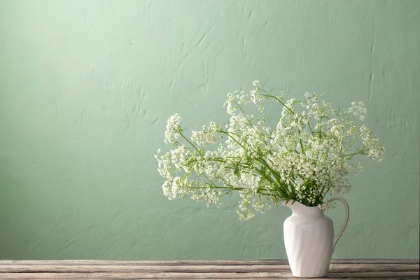 Białe Dzikie Kwiaty Dzbanku Tle Zielony Ściana — Zdjęcie stockowe