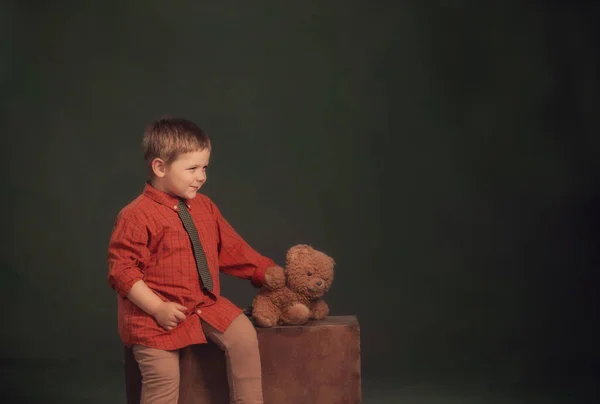 带着玩具熊和黑色背景的旧手提箱的小男孩 — 图库照片