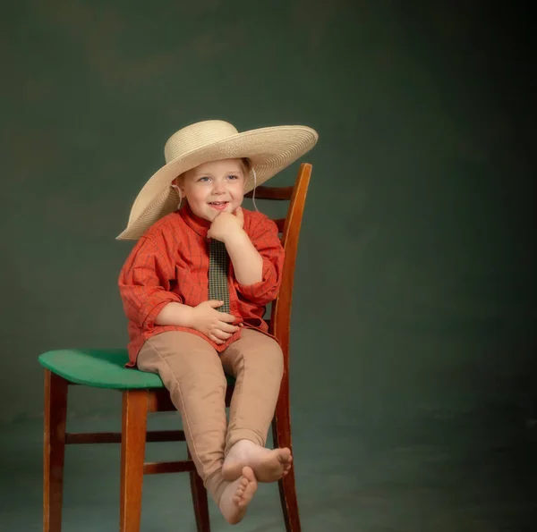 Büyük Şapkalı Küçük Mutlu Çocuk Kırmızı Gömlekli Eski Sandalyede Koyu — Stok fotoğraf