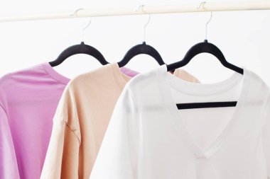 Beyaz arka planda asılı kadın tişörtleri