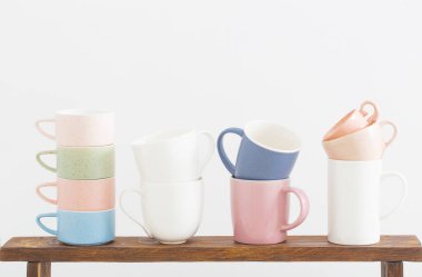 Beyaz arkaplanda ahşap raflarda renkli bardaklar