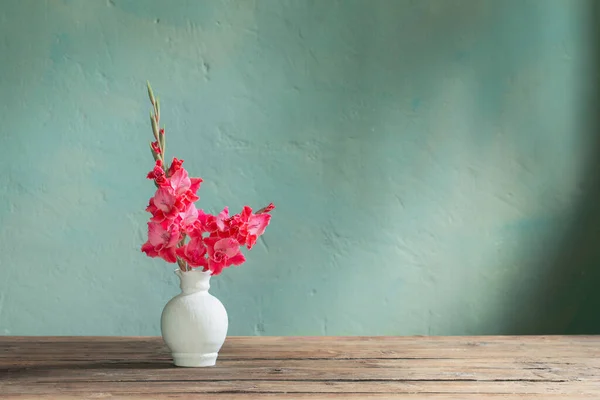 Arkadaki Yeşil Duvarda Beyaz Vazoda Pembe Gladiolus — Stok fotoğraf