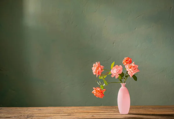 Розовые Розы Стеклянной Розовой Вазе Деревянном Столе Фоне Темной Стены — стоковое фото