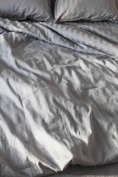 卧室床上阳光下的灰蒙蒙的亚麻布 — 图库照片