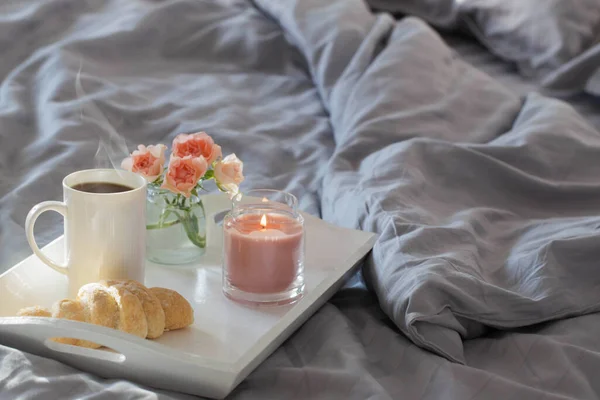 Φλιτζάνι Καφέ Κρουασάν Και Ροζ Τριαντάφυλλα Στο Κρεβάτι Στο Υπνοδωμάτιο — Φωτογραφία Αρχείου