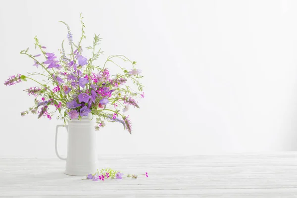 白色背景的白色水壶中的夏天野花 — 图库照片