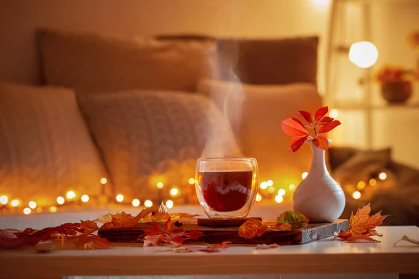 Koyu Gece Odasında Sonbahar Yapraklı Sıcak Çay Bardağı — Stok fotoğraf