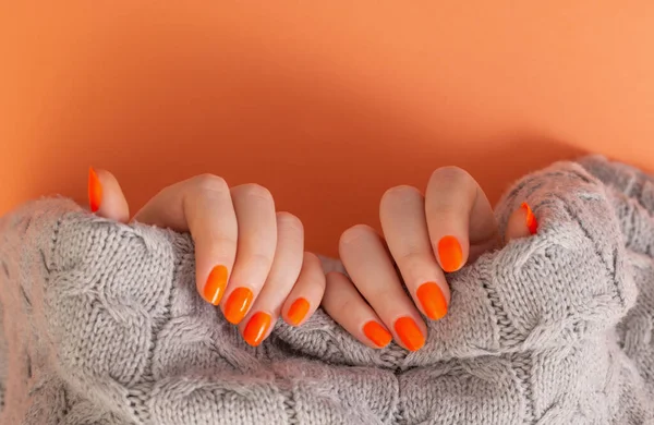 Manos Femeninas Con Manicura Naranja Sobre Fondo Naranja — Foto de Stock