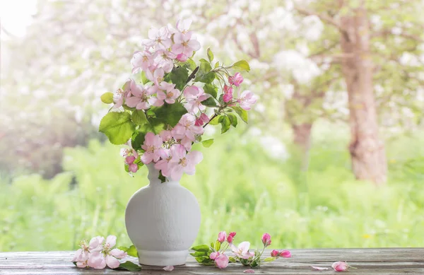 春の庭の白い花瓶にリンゴの花 — ストック写真