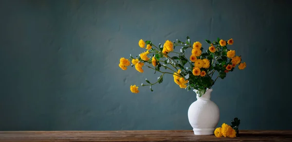白色花瓶中的黄色菊花 背景黑暗的墙 — 图库照片