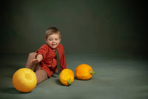 Liten Pojke Med Pumpor Mörkgrön Bakgrund — Stockfoto