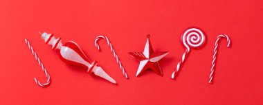 Kırmızı arkaplanda beyaz ve kırmızı noel süslemeleri