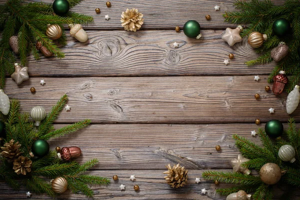 Koyu Ahşap Arka Planda Köknar Dalları Olan Altın Noel Oyuncakları — Stok fotoğraf