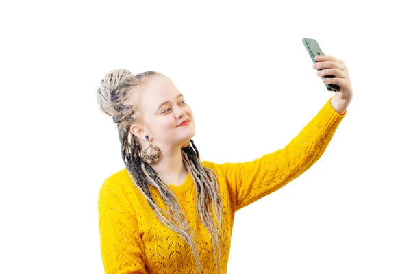 白い背景にスマートフォンが孤立した黄色のセーターの若い女性 — ストック写真
