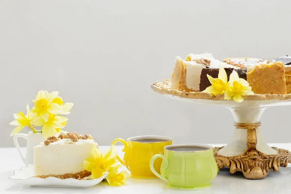 Bir Fincan Kahveli Cheesecake Beyaz Masada Sarı Bahar Çiçekleri — Stok fotoğraf