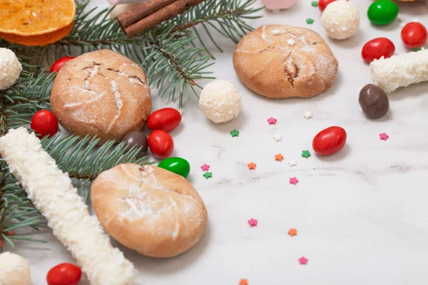Beyaz Mermer Arka Planda Noel Ağacı Dalları Olan Şekerler Kurabiyeler — Stok fotoğraf