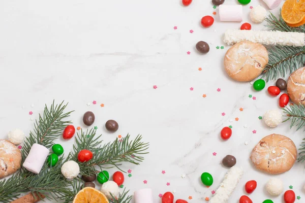 Bonbons Und Plätzchen Mit Weihnachtsbaumzweigen Auf Weißem Marmorhintergrund — Stockfoto