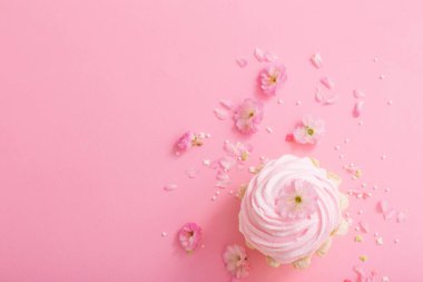 Pembe arka planda bahar çiçekleri olan pembe kek.