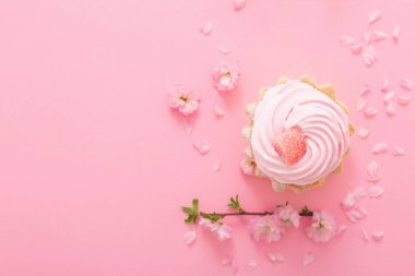 Pembe arka planda bahar çiçekleri olan pembe kek.