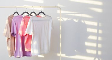 Beyaz arka planda asılı kadın tişörtleri