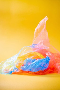 Parlak sarı arkaplanda plastik çöp