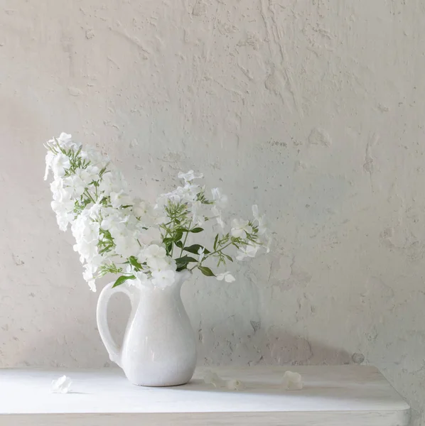 白い背景にヴィンテージの木のテーブルの上の花瓶のPhloxes — ストック写真