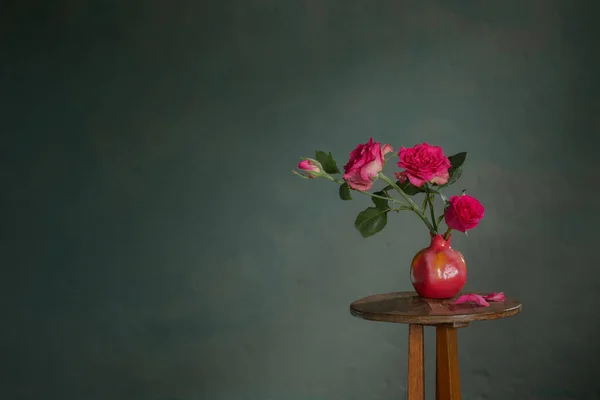 底色深绿色墙上粉色花瓶中的粉红玫瑰 — 图库照片