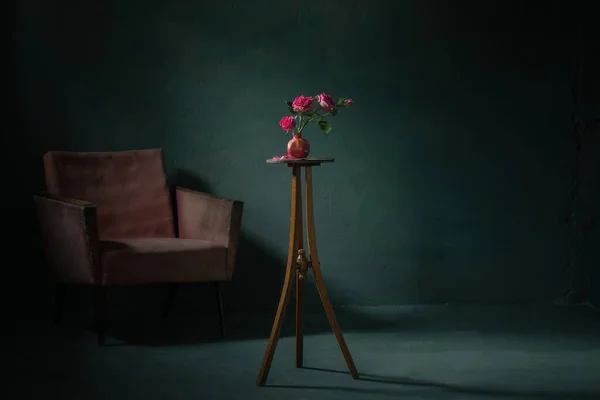 粉红的玫瑰在粉红的花瓶里 背墙有一把旧扶手椅 — 图库照片