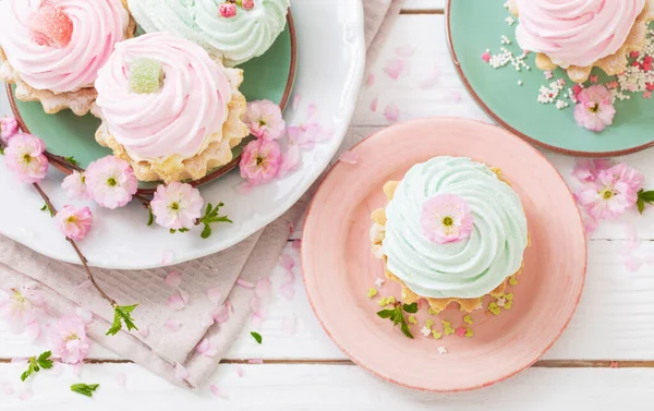 Rosa Und Grüne Cupcakes Mit Frühlingsblumen Auf Weißem Holzhintergrund — Stockfoto