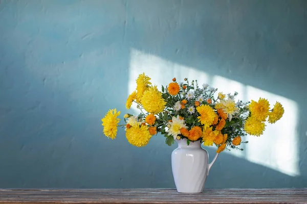 木桌上白色水壶中的黄 白菊花 — 图库照片