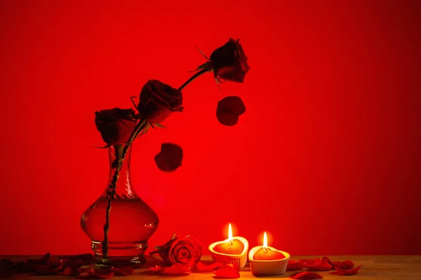 Силуэт Роз Вазе Горящими Свечами Красном Фоне — стоковое фото