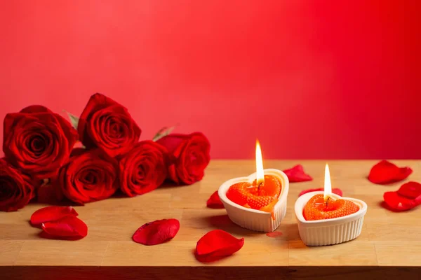 赤い背景に燃えるろうそくのある赤いバラ — ストック写真
