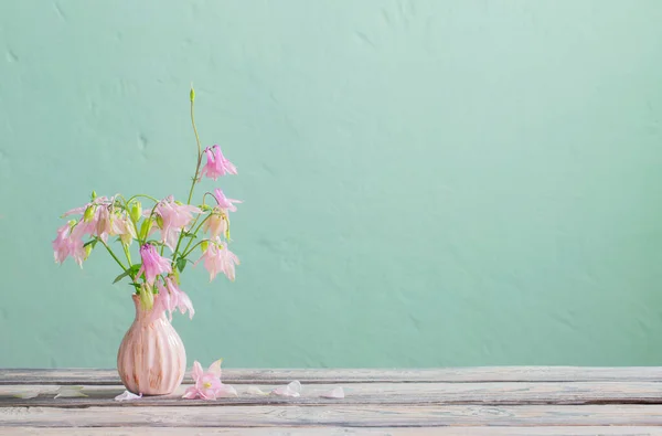 背景绿墙上粉色花瓶中的粉红花朵 — 图库照片