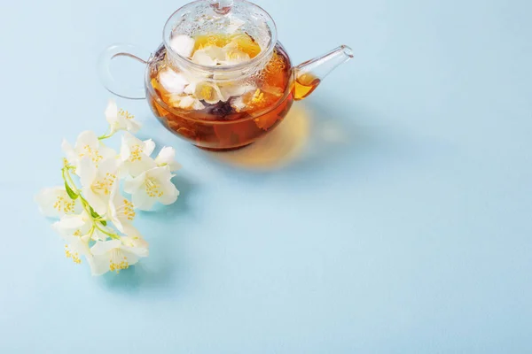 stock image jasmine tea in glass teapot on blue background