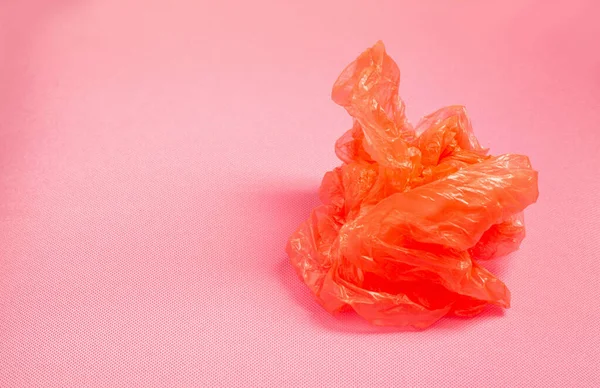 Pomarańczowy Plastikowy Worek Różowym Tle — Zdjęcie stockowe