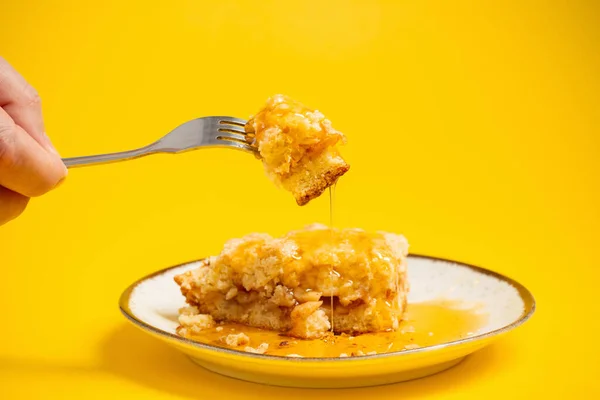 黄色の背景に蜂蜜を盛り付けたケーキ — ストック写真