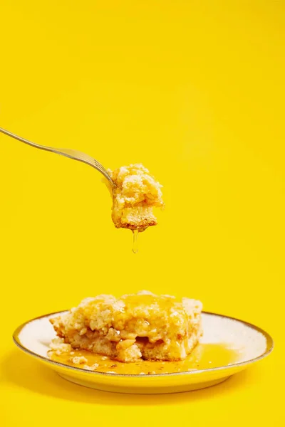 黄色の背景に蜂蜜を盛り付けたケーキ — ストック写真