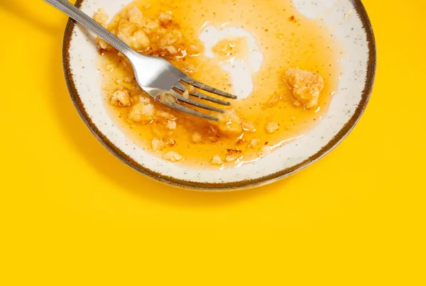 stock image dirty plate with honey and pie crumbs on yellow background