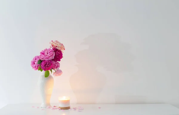 Rosa Rosen Der Vase Und Brennende Kerze Auf Weißem Hintergrund — Stockfoto